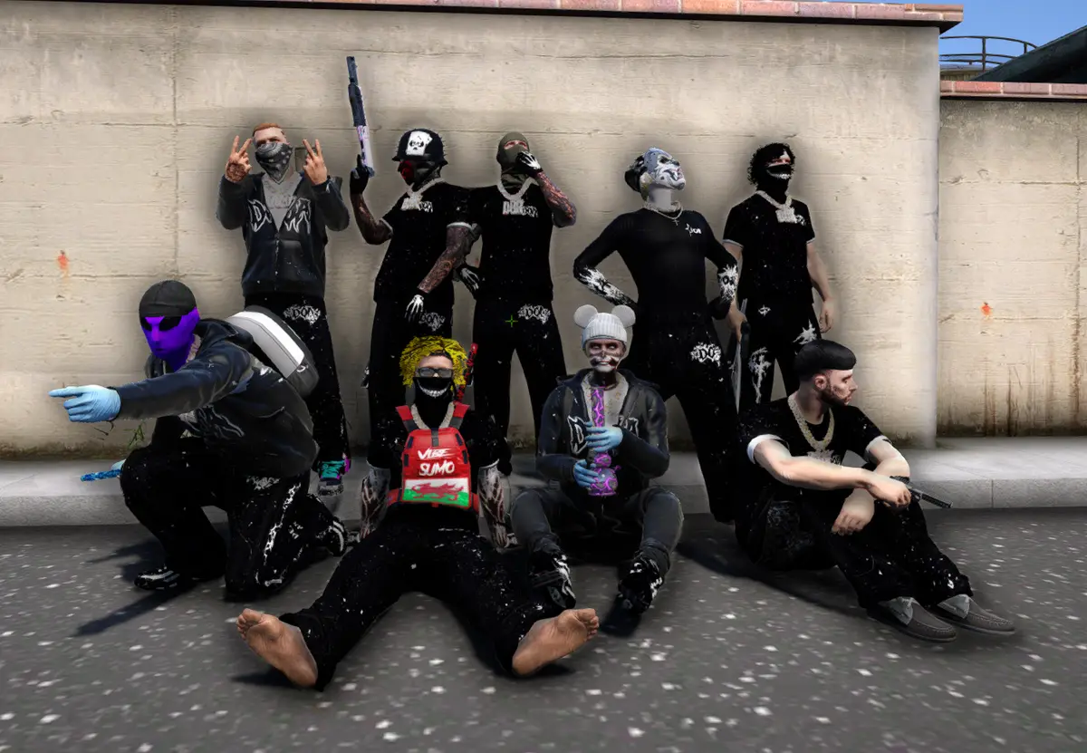 A masked DRILL UK gang in black and white streetwear posed against a wall, three sat on the pavement and one holding a shotgun